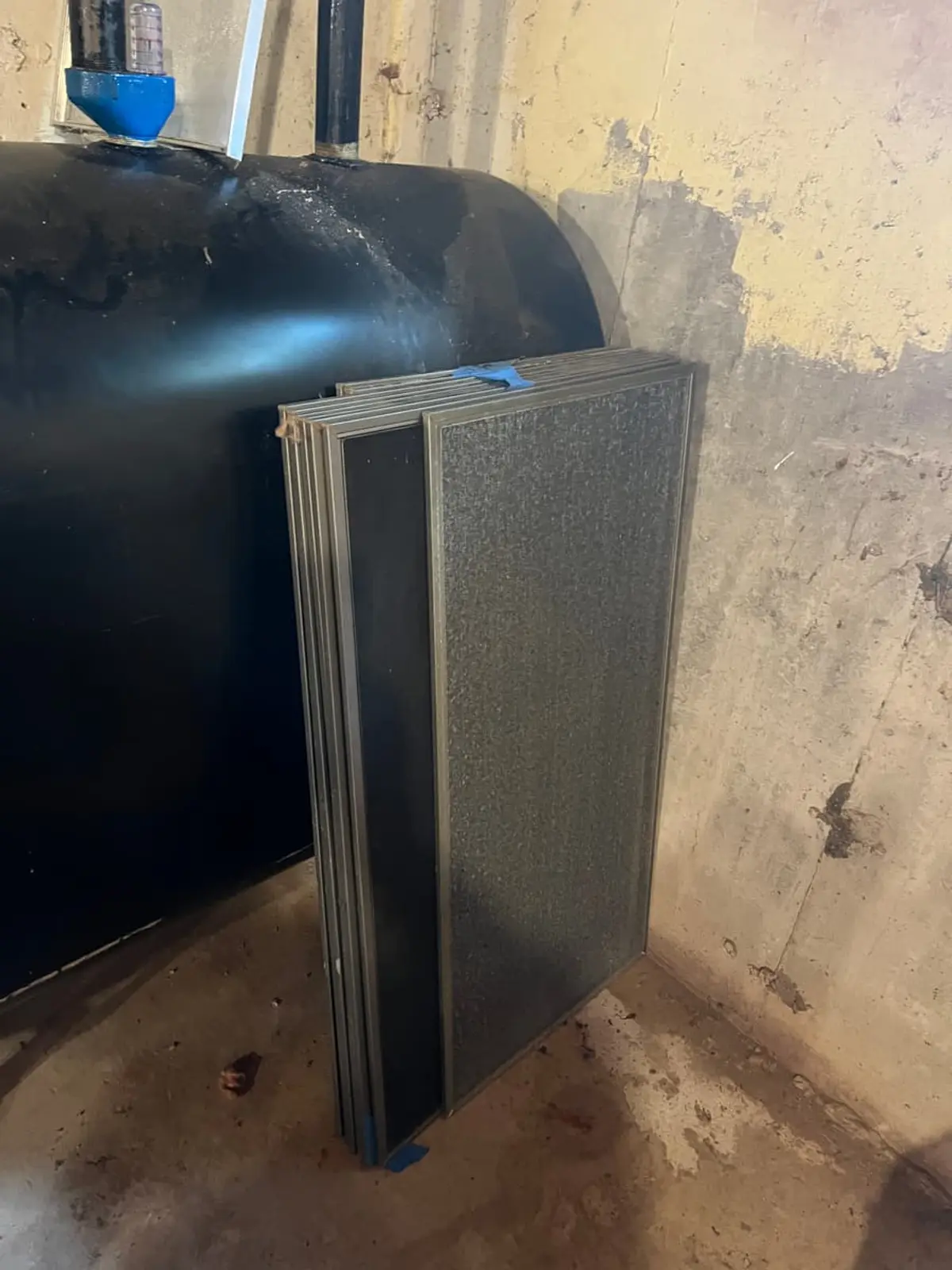 Selling a house with an oil tank in Riverhead: black oil tank against a stained concrete wall