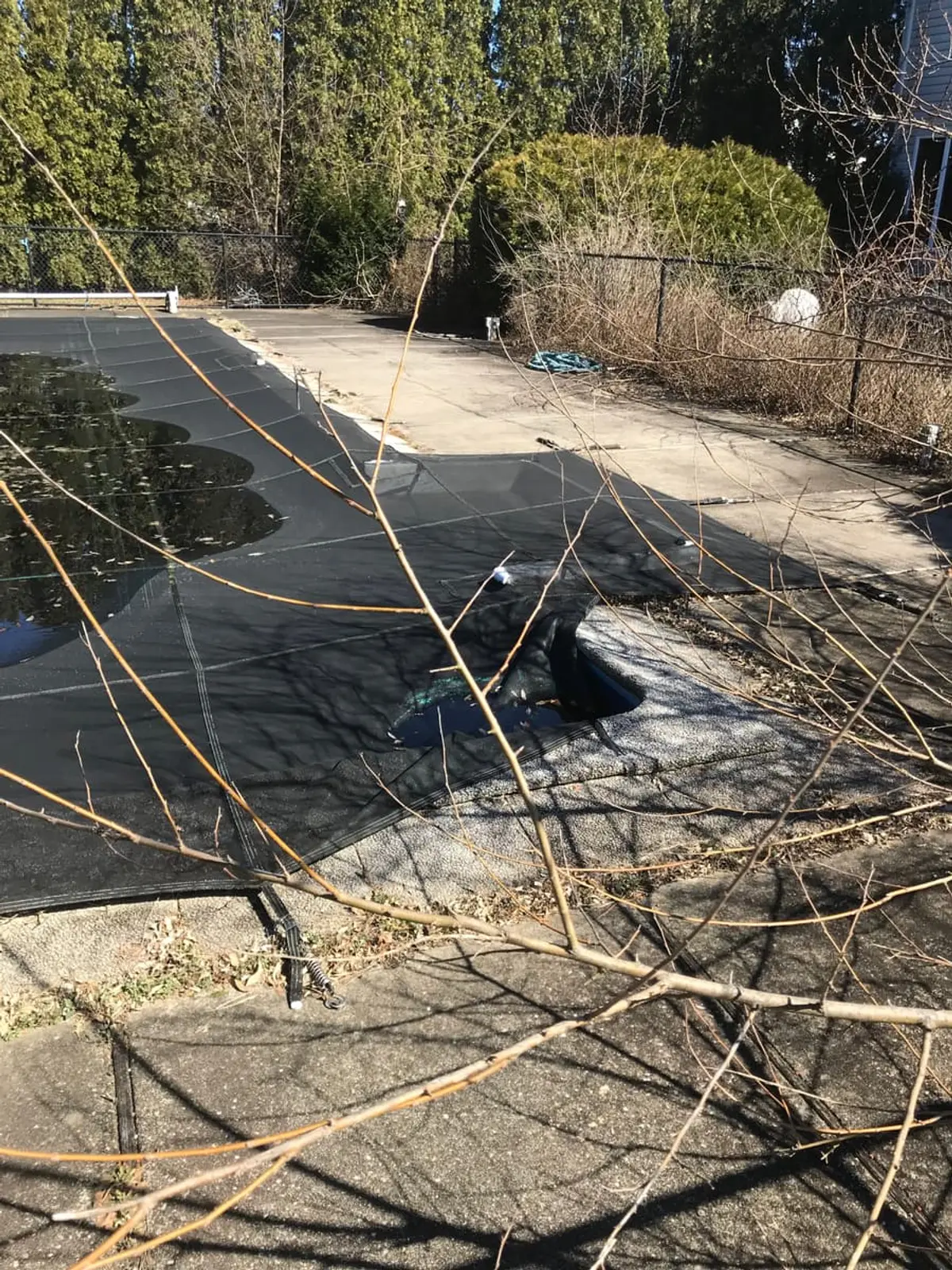 Selling a house with a failed cesspool in Riverhead: covered inground pool with weeds along the fence