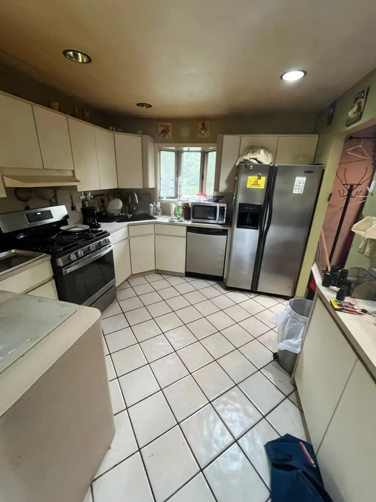 Behind on mortgage payments in Riverhead: cream kitchen with stainless appliances and white tile