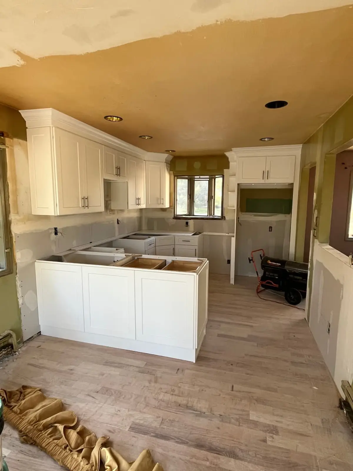 Selling a house as-is in Riverhead: new white shaker cabinets waiting on countertops