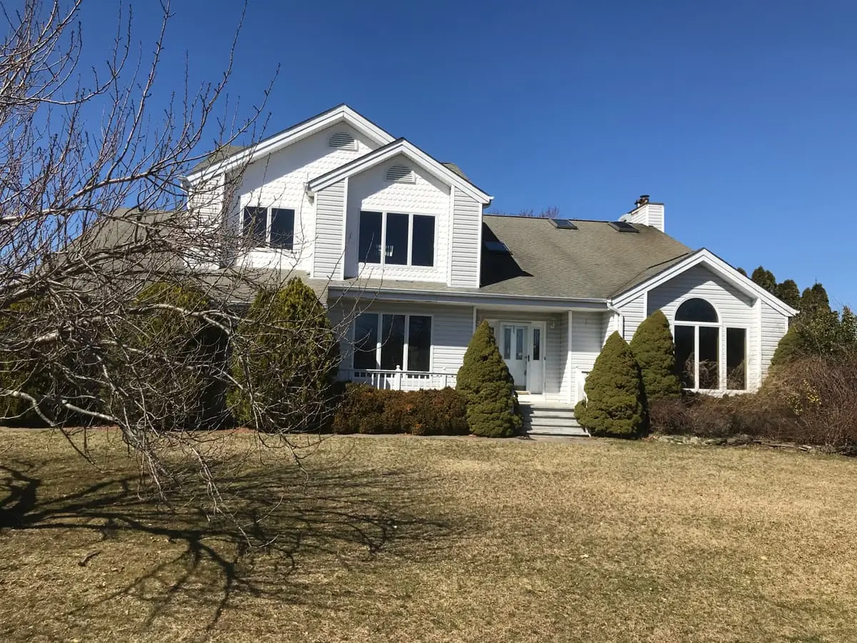 Selling in the Riverhead housing market: two story colonial with arched windows and winter lawn