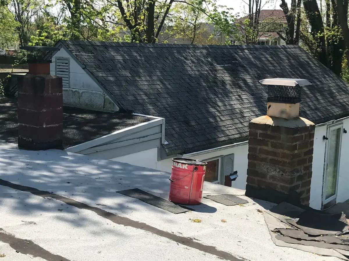 Selling a storm-damaged house in Riverhead: worn shingle roof and chimneys seen from above